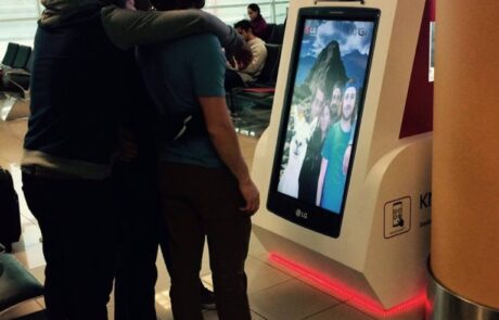 Jóvenes tomándose un selfie en tótem interactivo LG en aeropuerto
