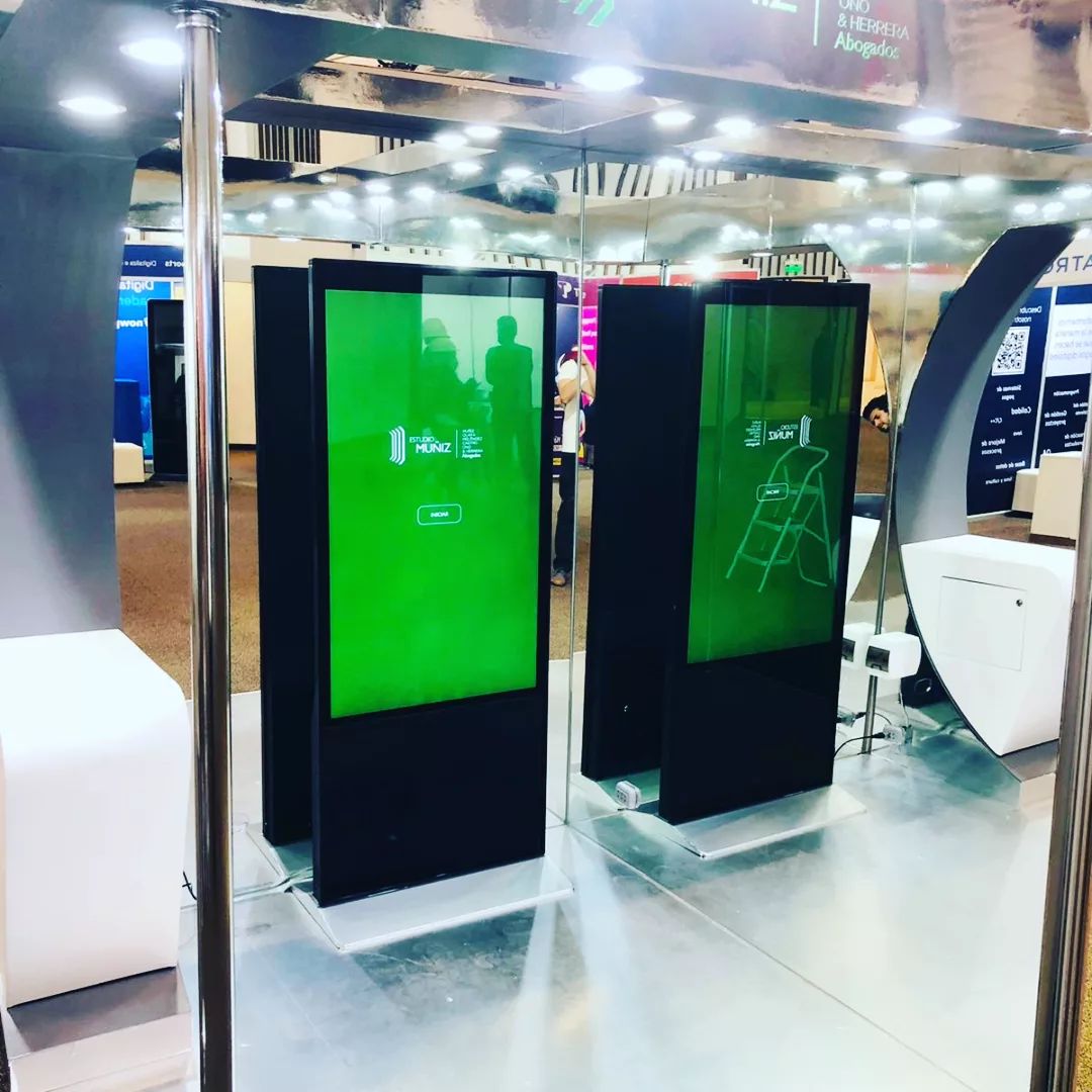 Tótems interactivos con pantallas verdes en stand de feria