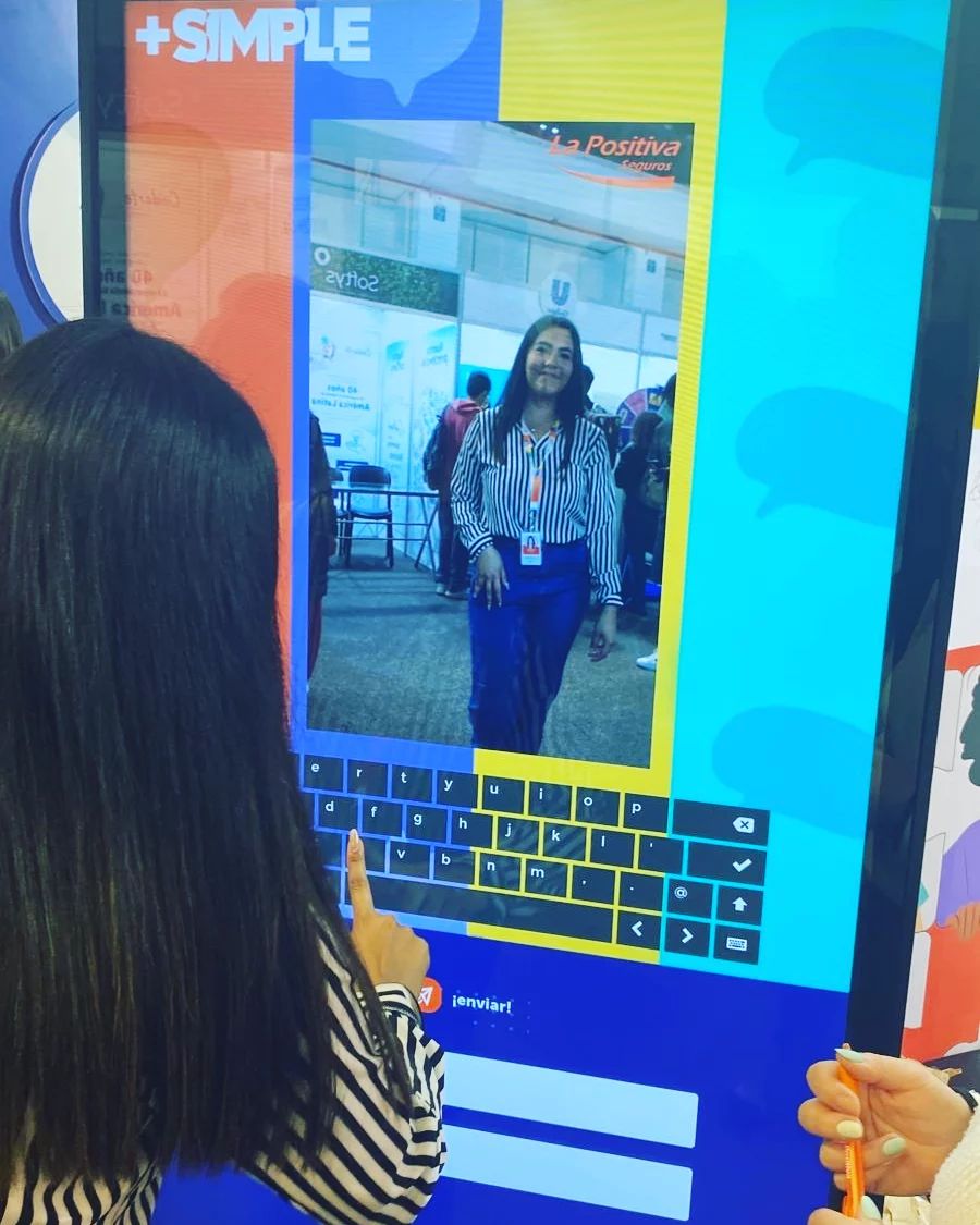 Mujer usando tótem interactivo con selfie y teclado en pantalla