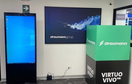 Tótem digital vertical en un stand de feria