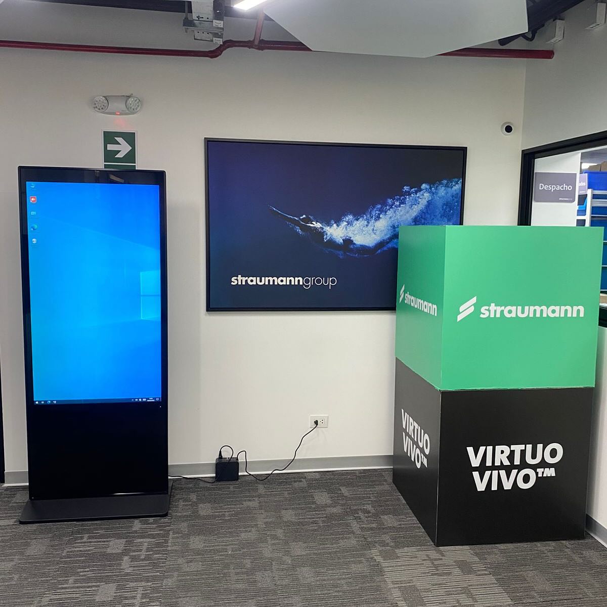 Tótem digital vertical junto a pantalla en stand de Straumann
